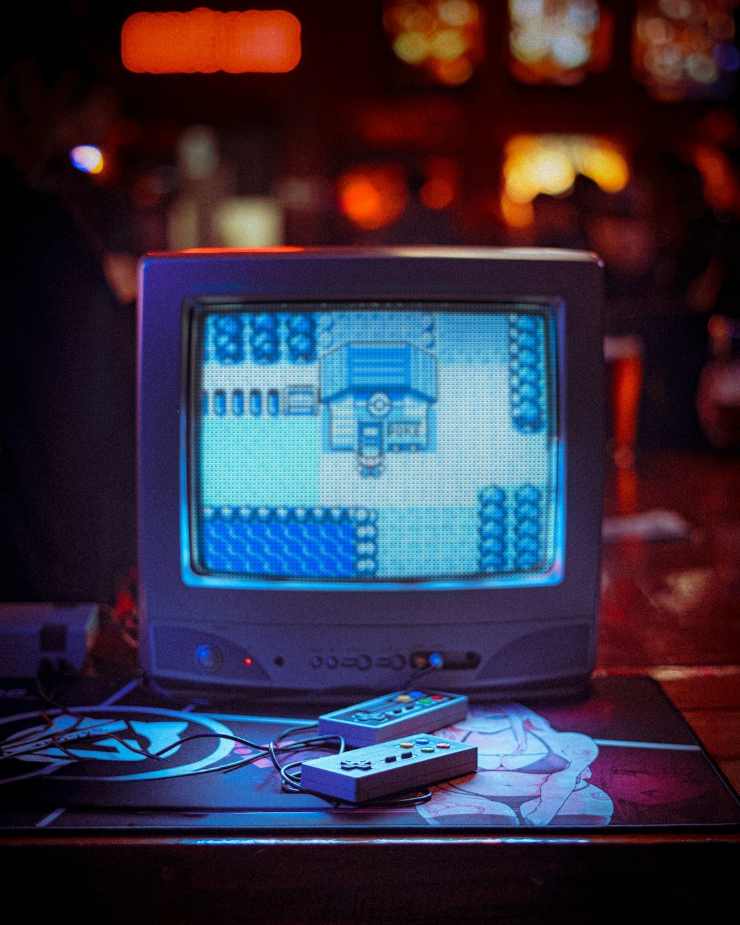 Une vieille télévision affiche un jeu vidéo en pixel art, entourée de manettes, dans une ambiance de coin rétro-gaming