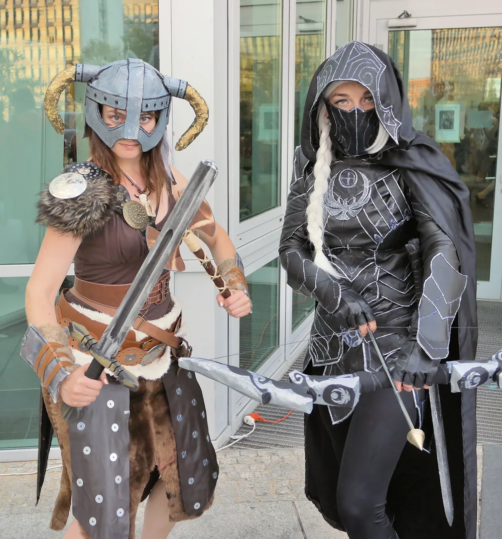 Deux cosplayeurs en tenue de Skyrim, l’un avec le casque à cornes, l’autre avec un arc