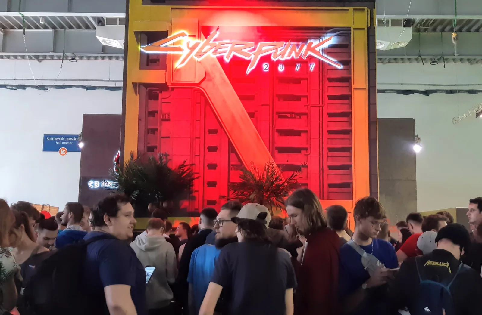 La façade du stand Cyberpunk 2077, avec le logo en néon rouge au-dessus de la foule
